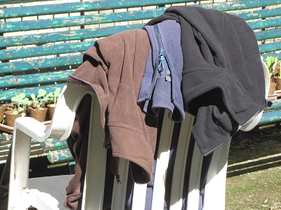Sweat-shirts en laine polaire sur un dossier de chaise d'extérieur.